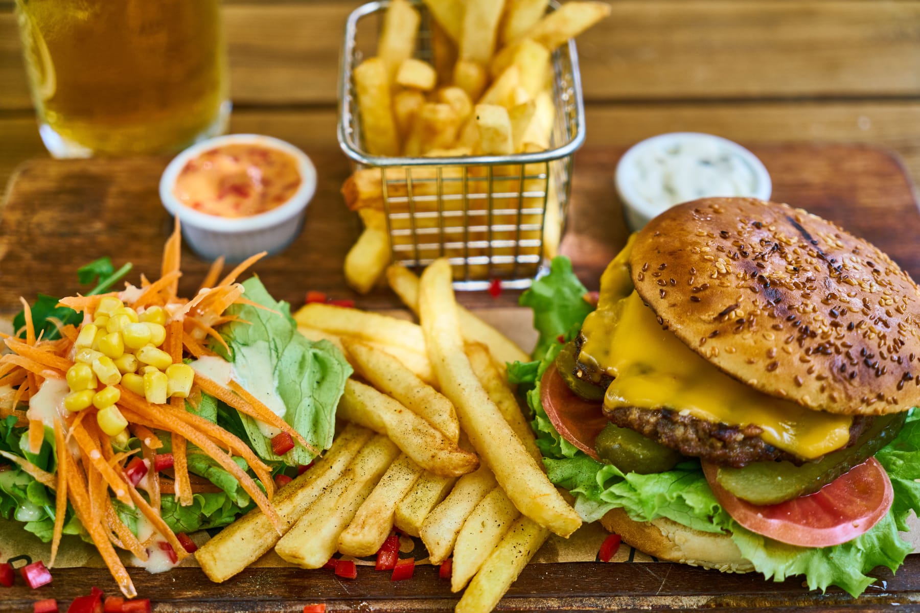 Sobrepeso infantil: hamburguesa, papas fritas y ensalada sobre una mesa